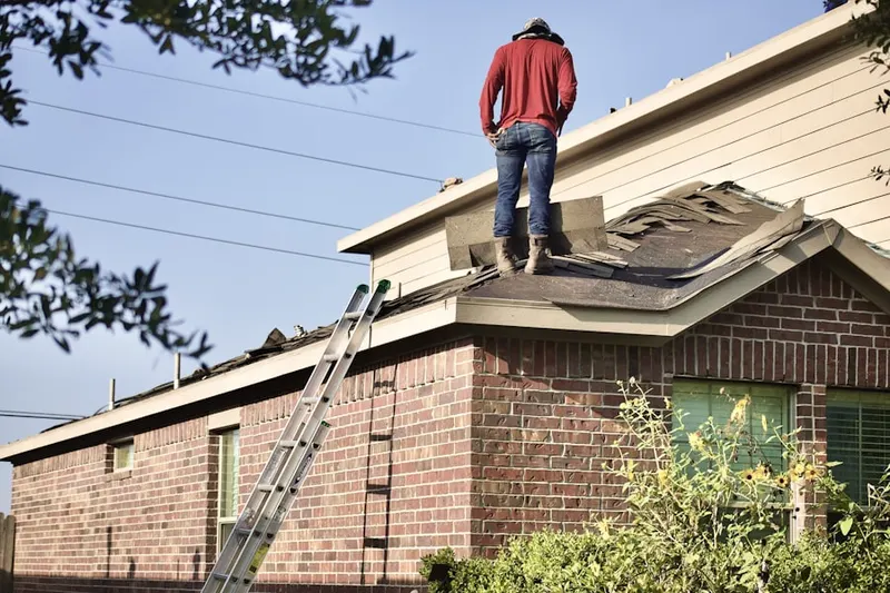 Professional roofer working on a residential roof in Lamar